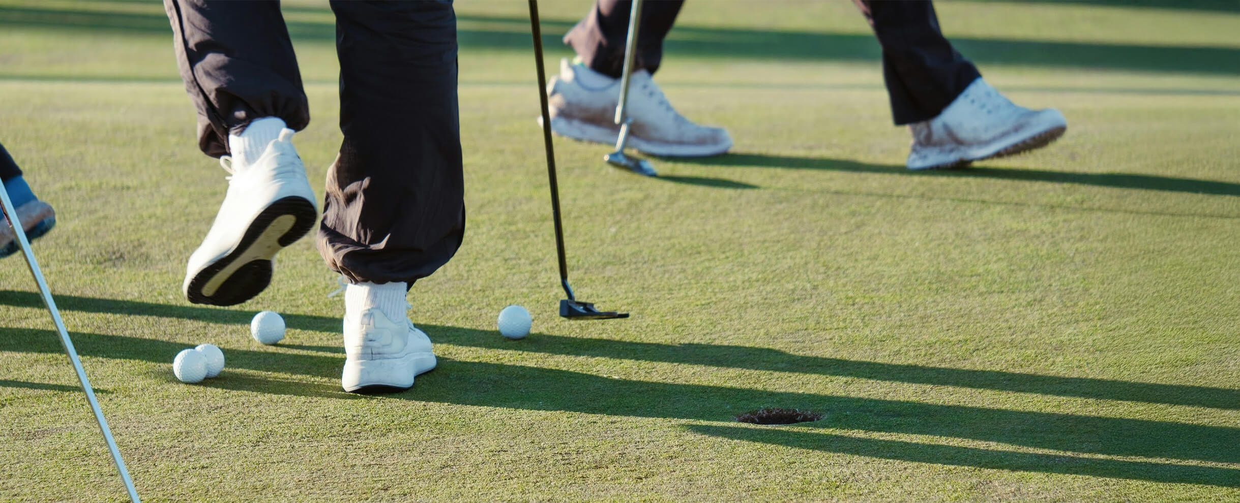 a golf ball and golf clubs on a green grass field