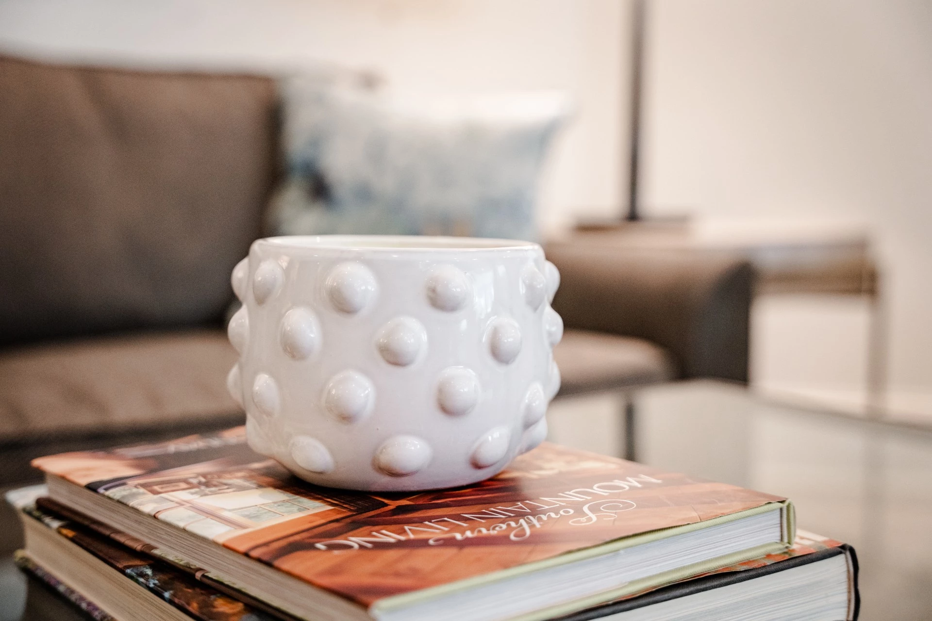 a white cup on a stack of magazines