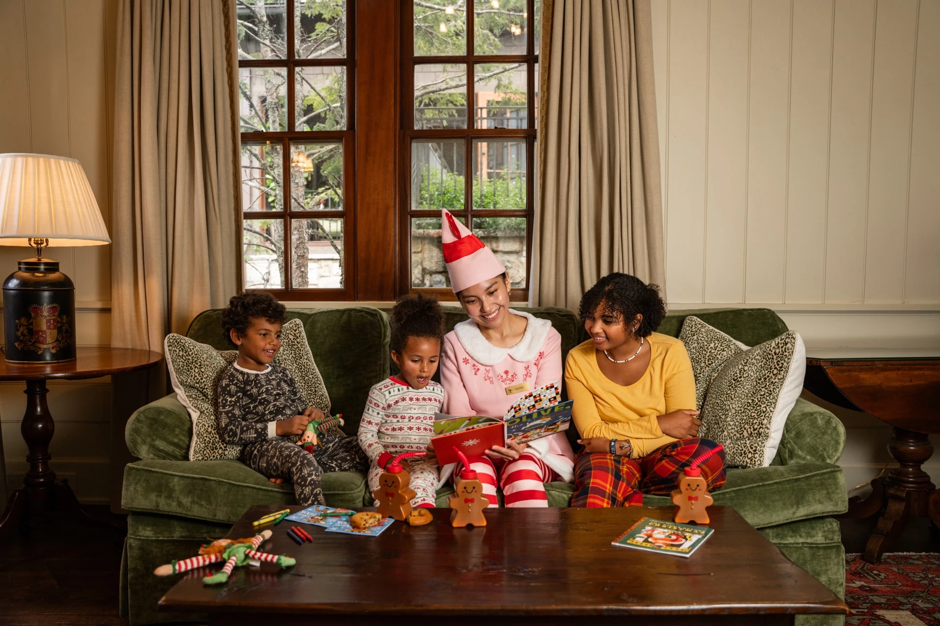 a woman and children sitting on a couch reading a book