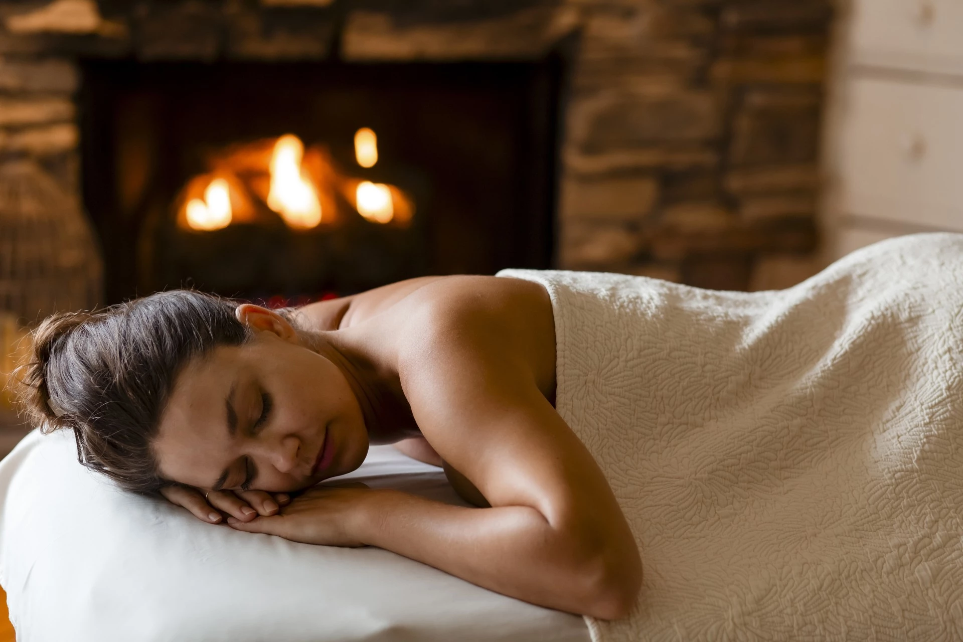 a woman lying on a bed with her eyes closed