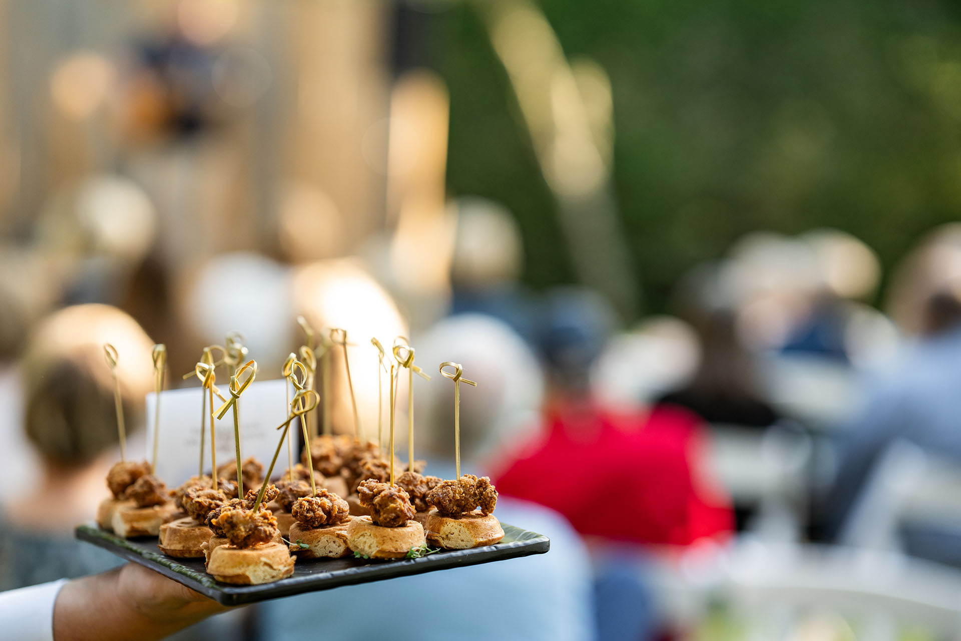a person holding a plate of appetizers