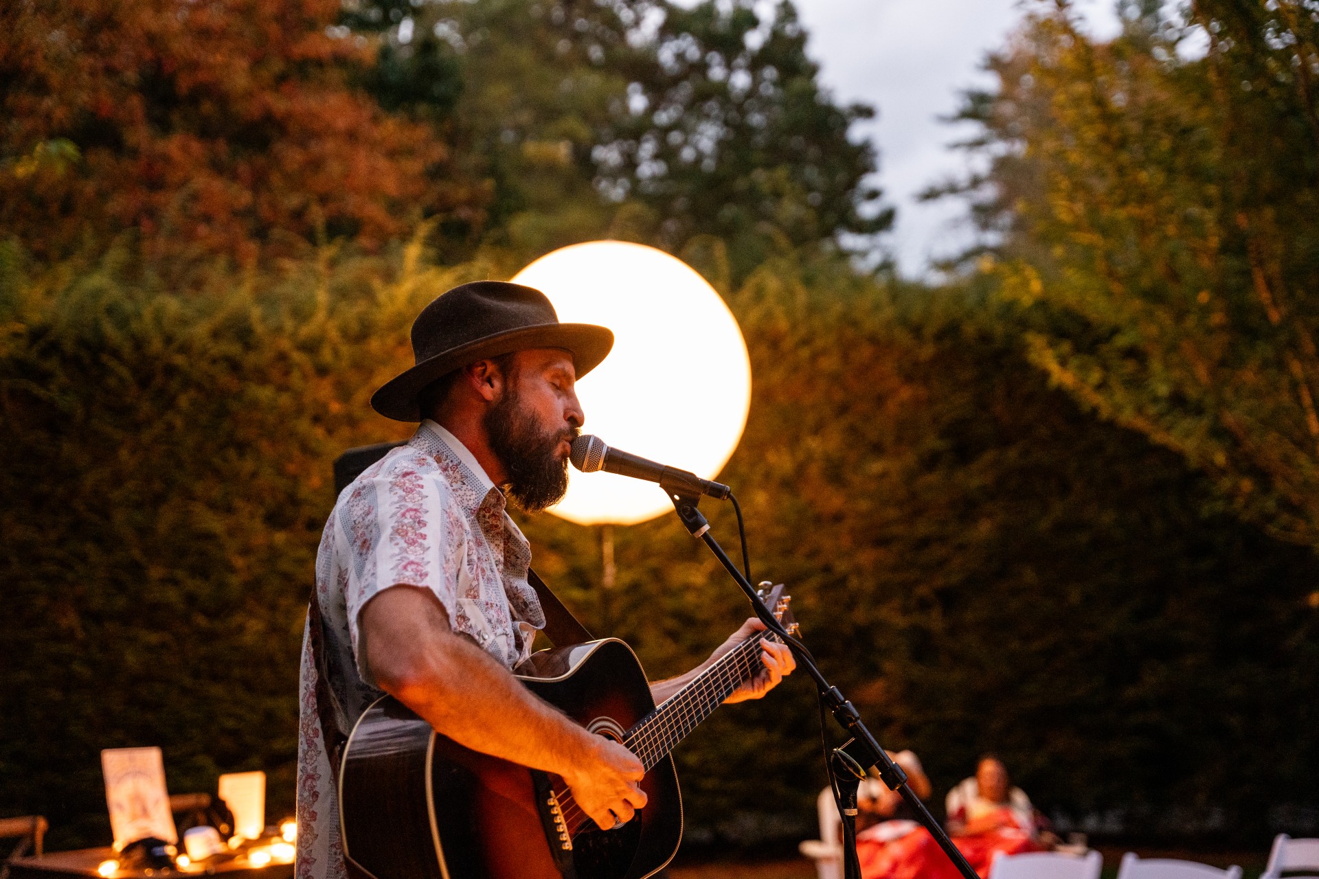 a man playing guitar and singing in front of a microphone