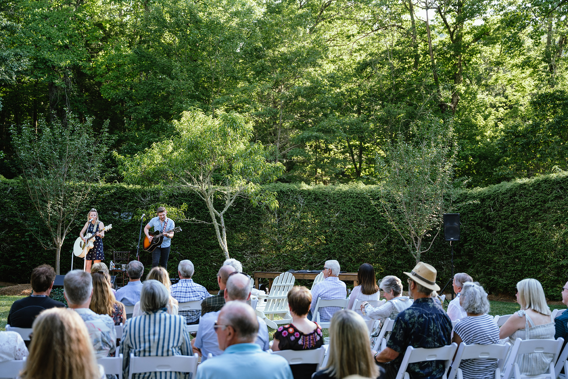 a group of people playing instruments in a garden