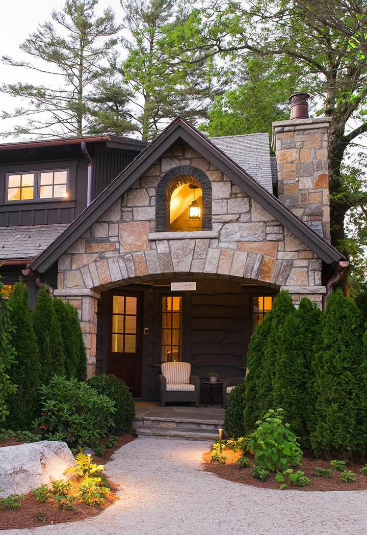 a house with a stone wall and a stone arch