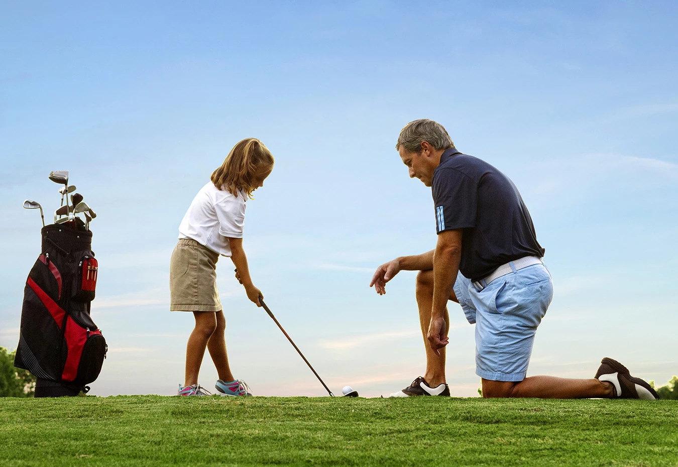 a man and a girl playing golf