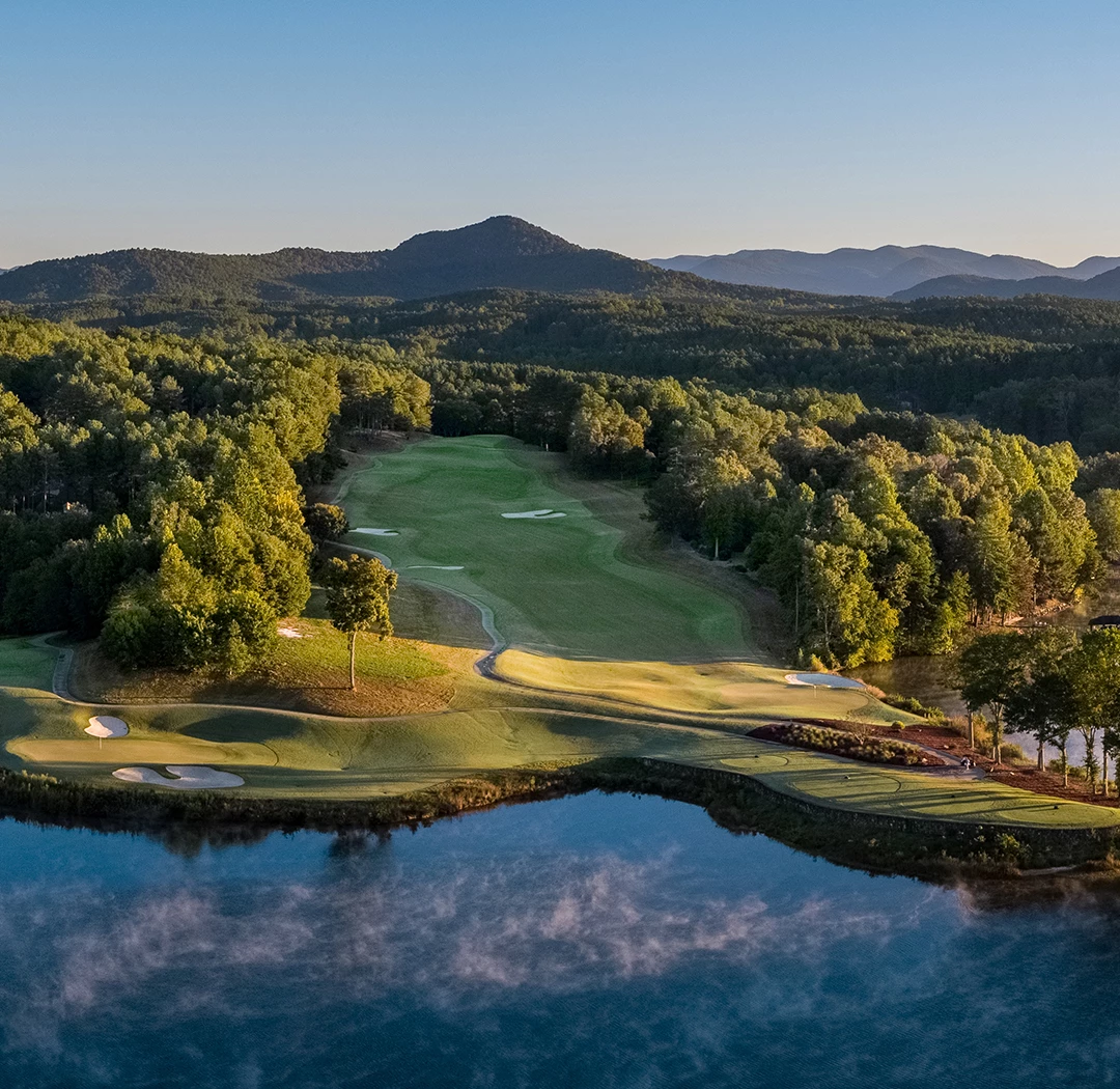 a golf course with a lake and trees