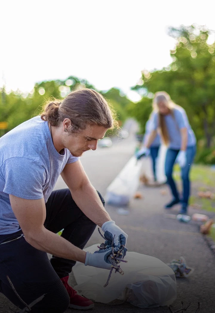 a man kneeling on the side of a road with a woman in the background