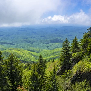 a landscape of a mountain range with trees and hills