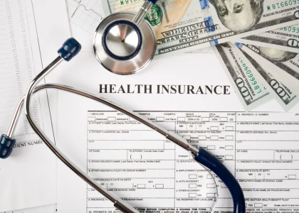 a stethoscope and money on a health insurance form
