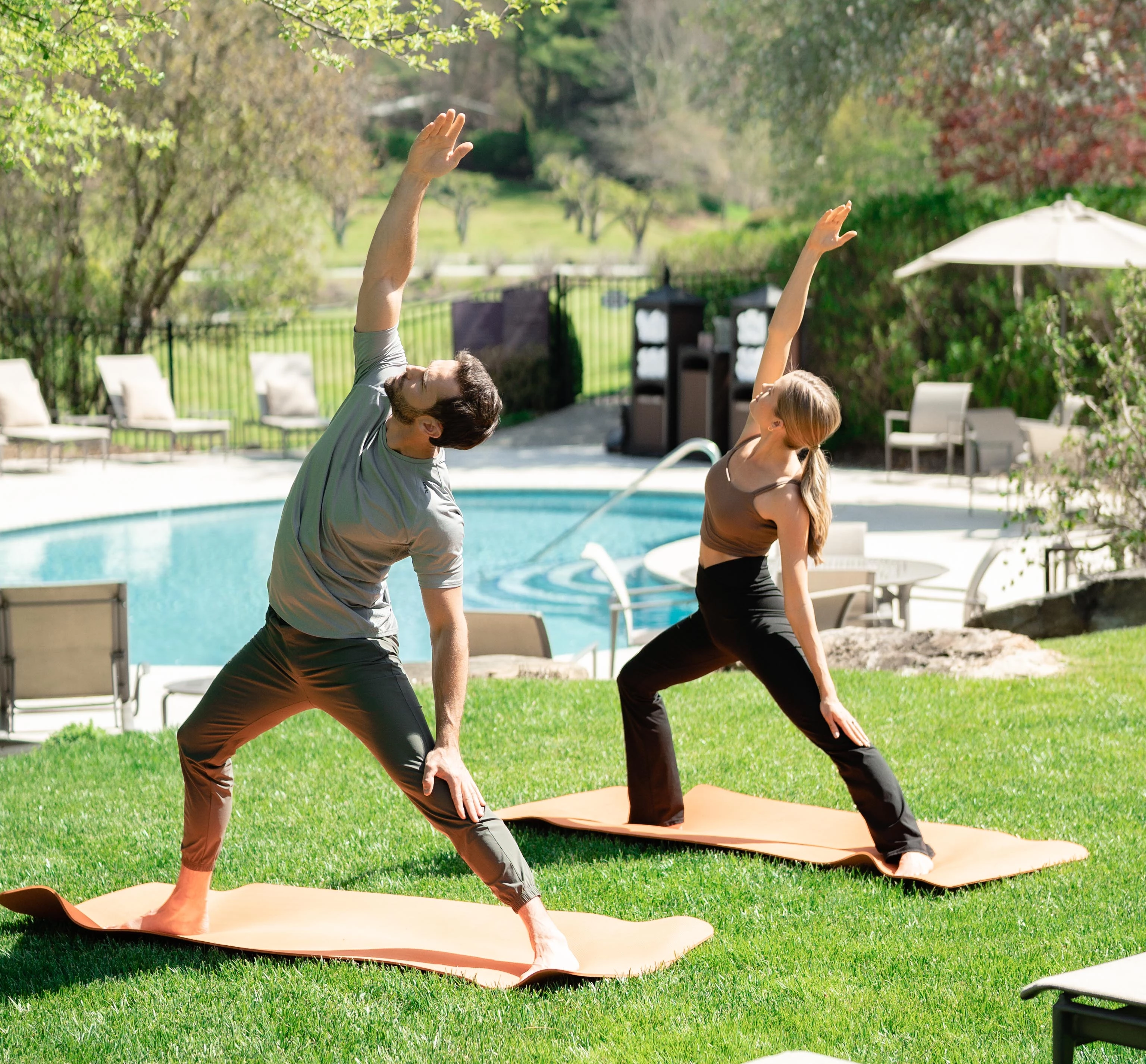 a man and woman doing yoga outside