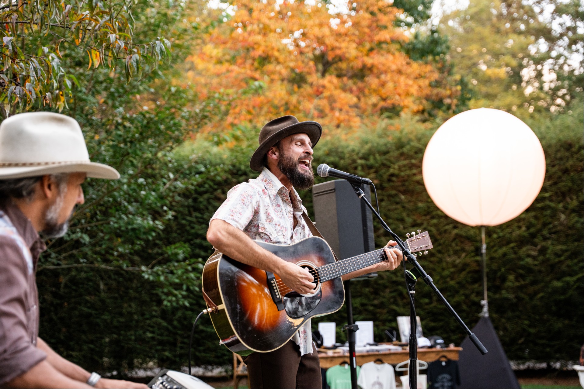 a man playing guitar and singing into a microphone