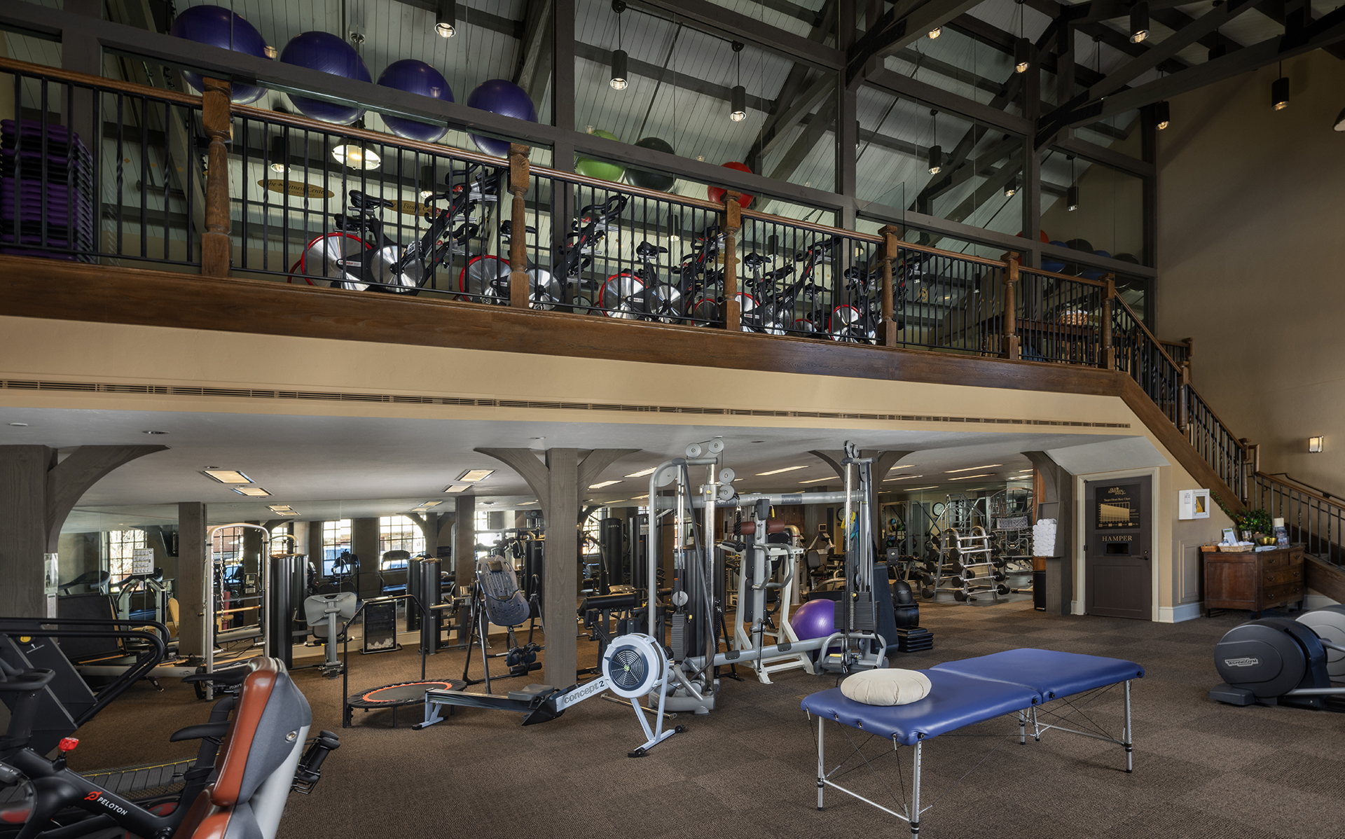 a gym with exercise equipment and a balcony