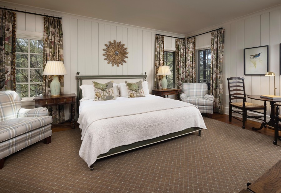 a bedroom with a bed and chairs