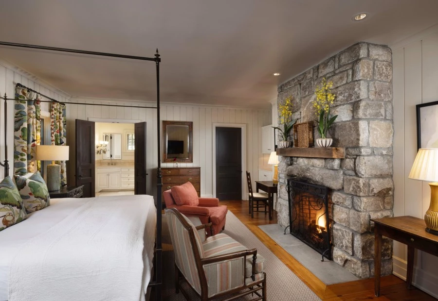 a room with a stone fireplace and a bed