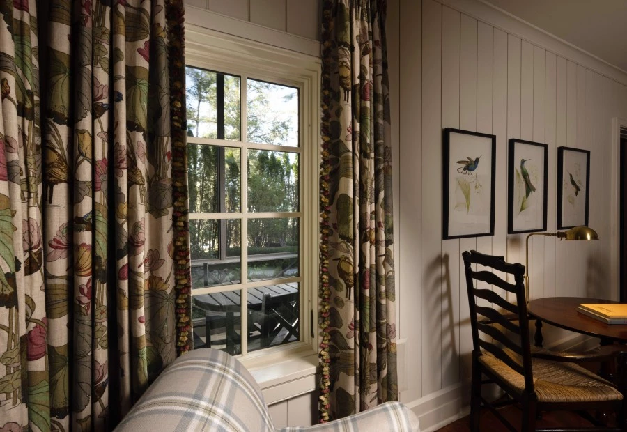 a room with a couch and chairs and a window