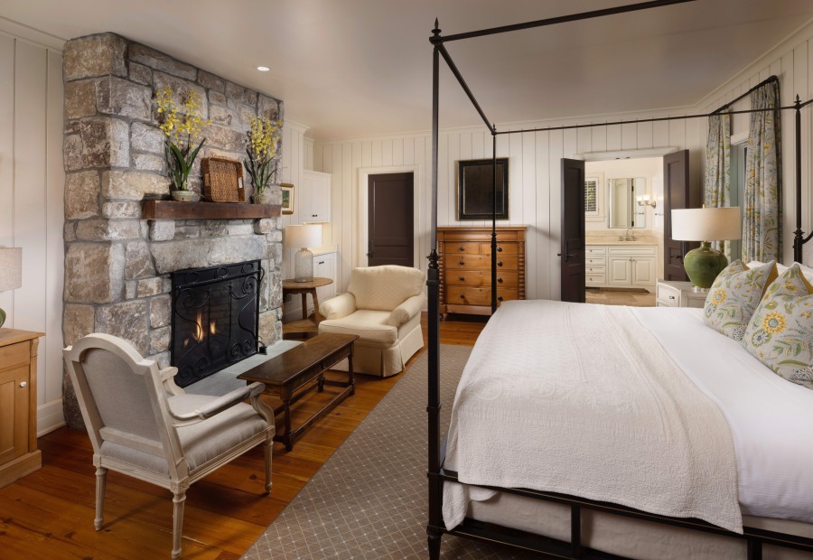 a bedroom with a stone fireplace and a bed