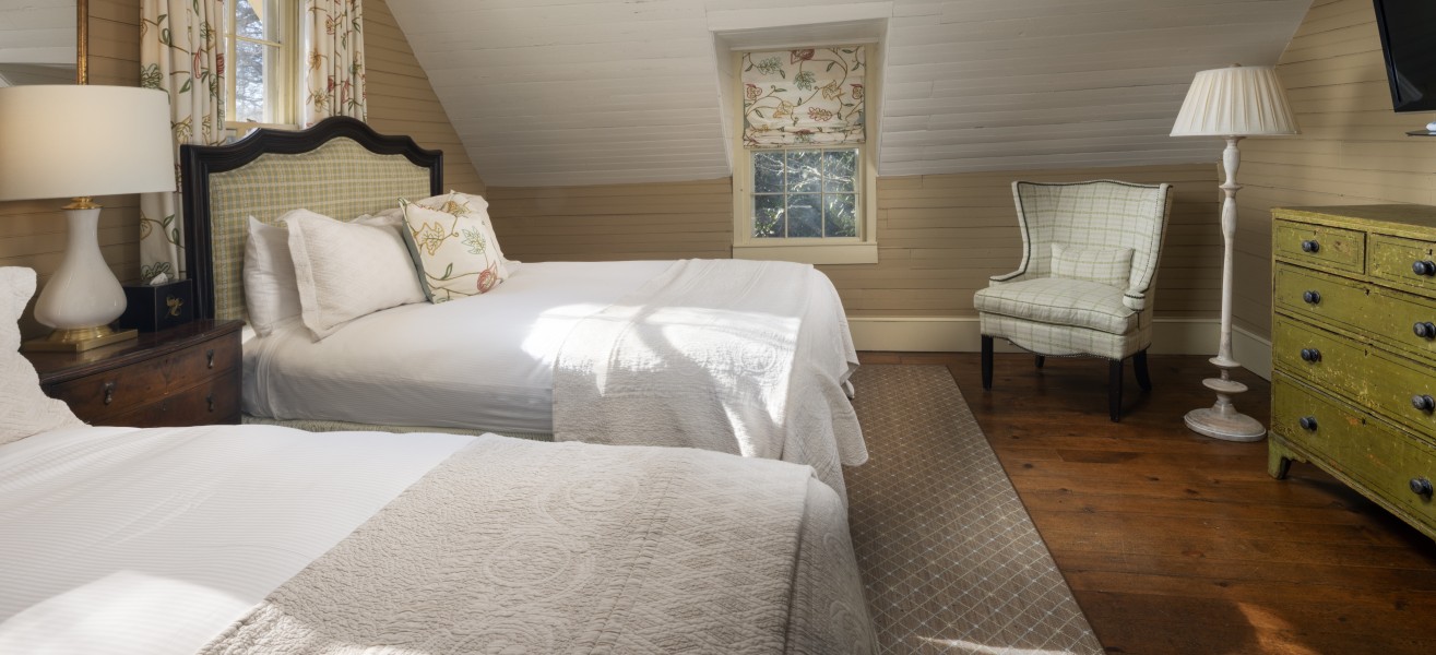 a bedroom with two beds and a chair