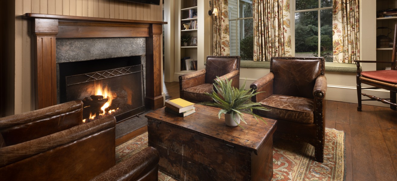 a living room with a fireplace and leather furniture