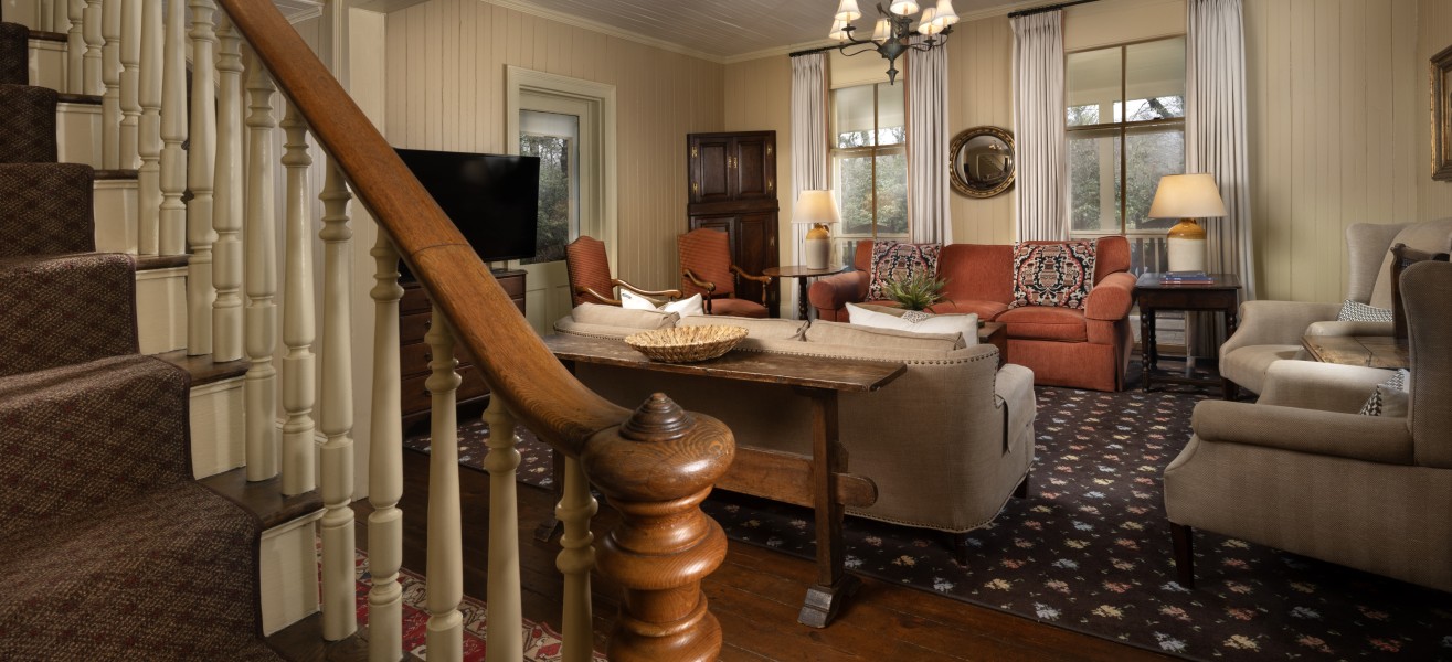 a living room with a staircase and couches