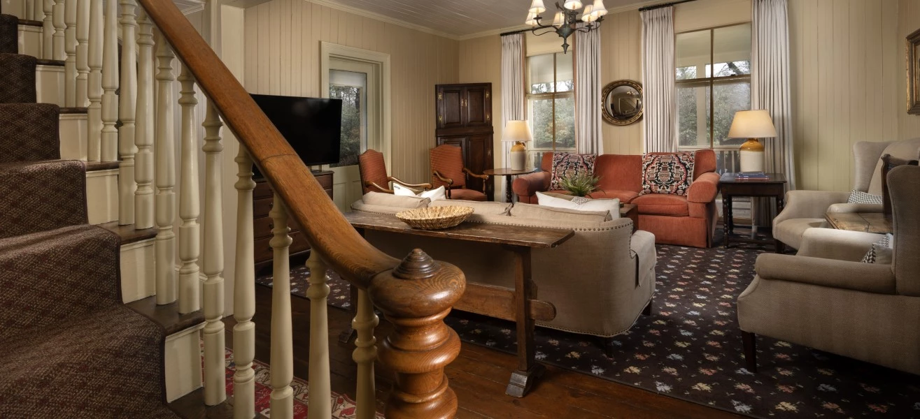 a living room with a staircase and couches