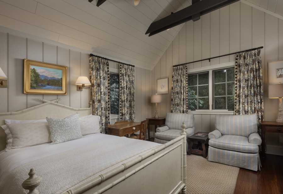 a bedroom with a bed and chairs