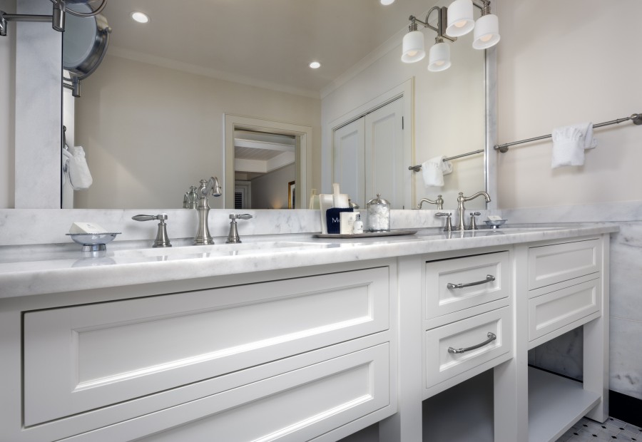 a bathroom with white cabinets and white counter tops