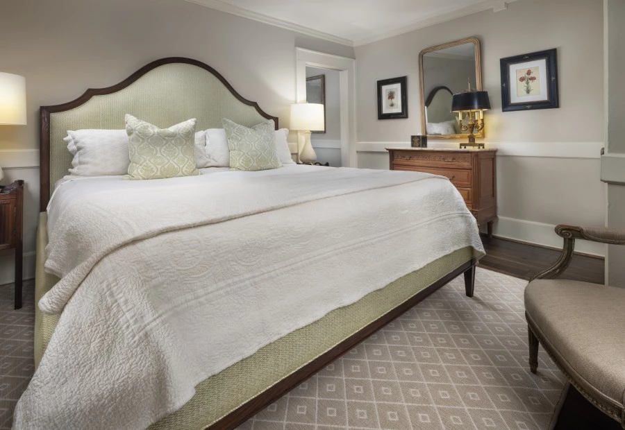 a bed with a white blanket and a lamp