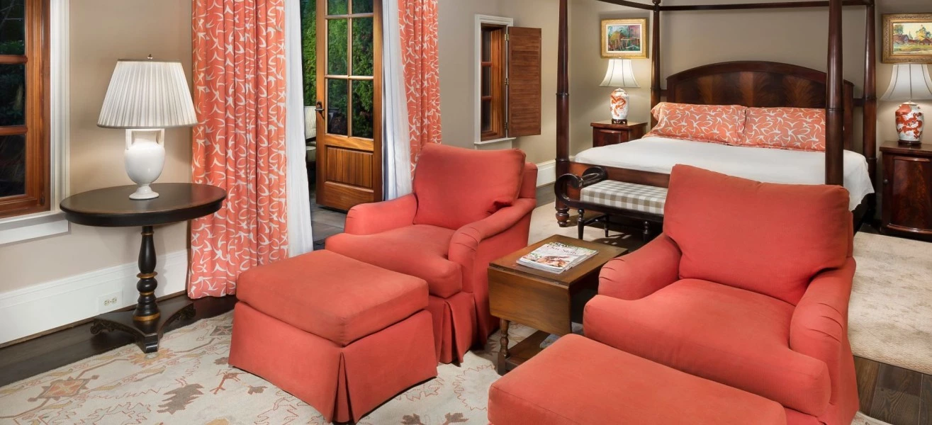 a room with a bed and chairs