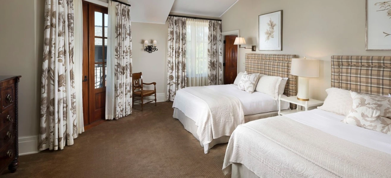 a bedroom with two beds and a fan