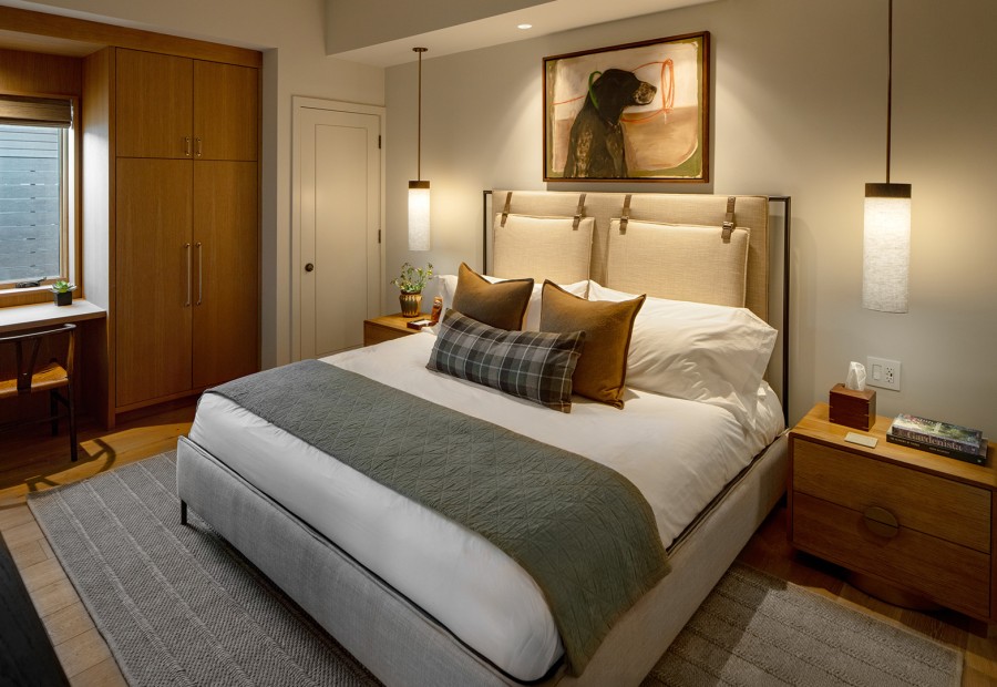 a bed with a large headboard and a painting on the wall