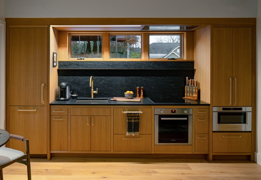 a kitchen with wood cabinets and a black countertop