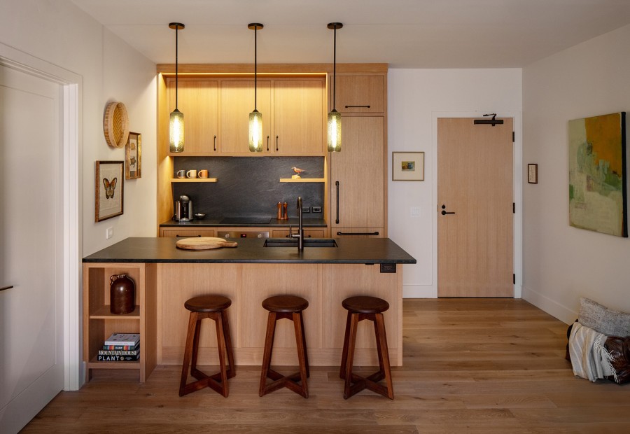 a kitchen with a bar stools and a wood floor