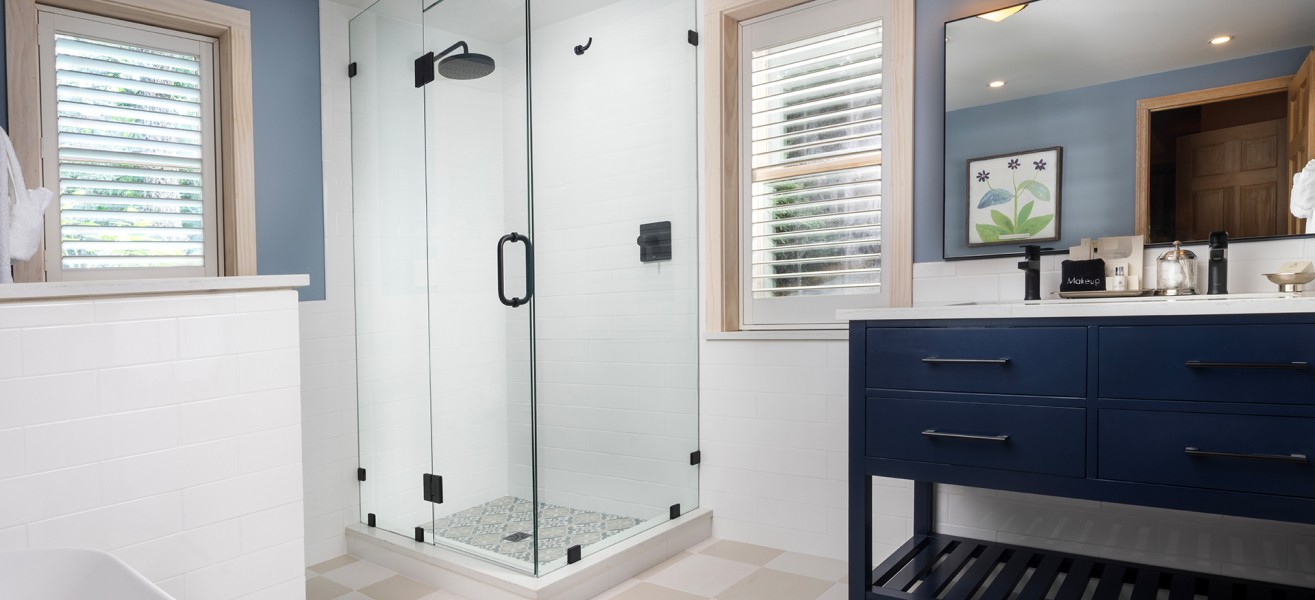 a bathroom with a glass shower and a blue vanity
