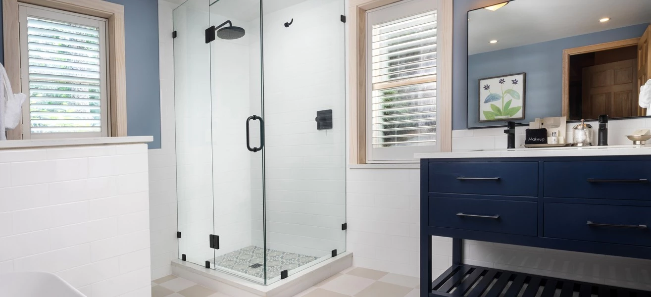 a bathroom with a glass shower and a blue vanity
