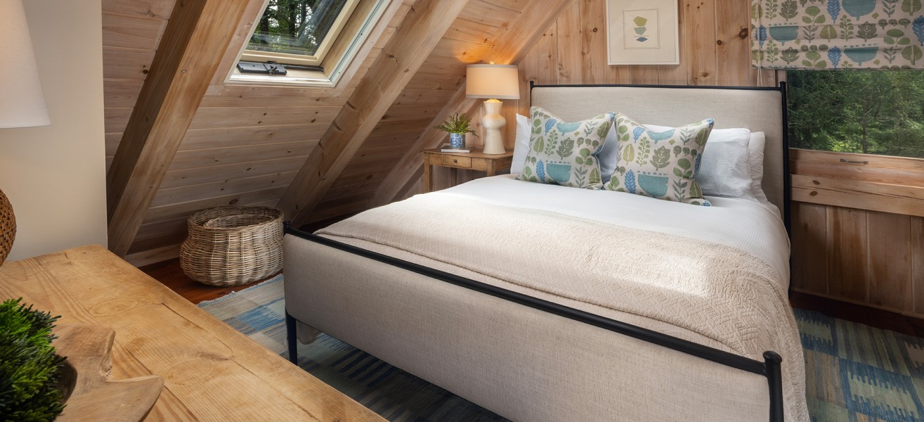 a bed in a room with a wooden wall and a table