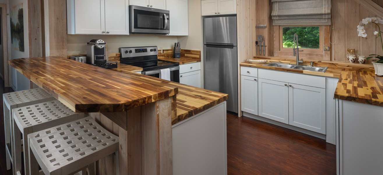a kitchen with white cabinets and wooden countertops