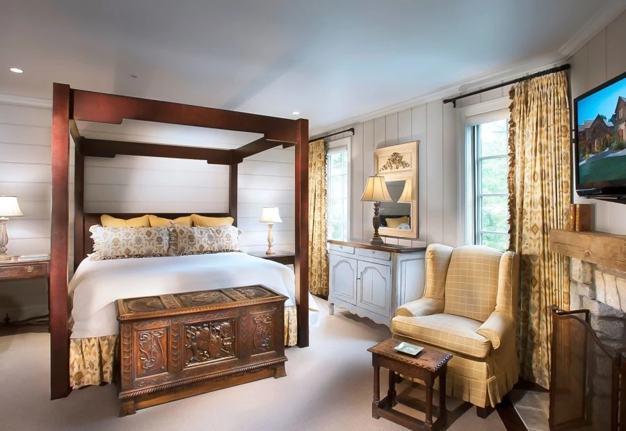 a bedroom with a canopy bed and a chair