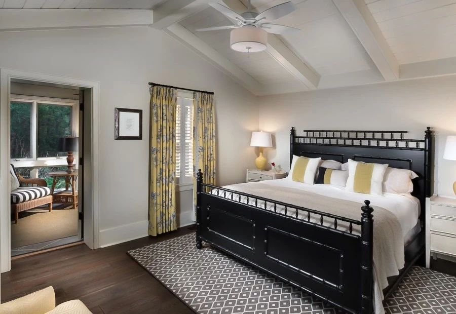 a bedroom with a black bed and yellow curtains