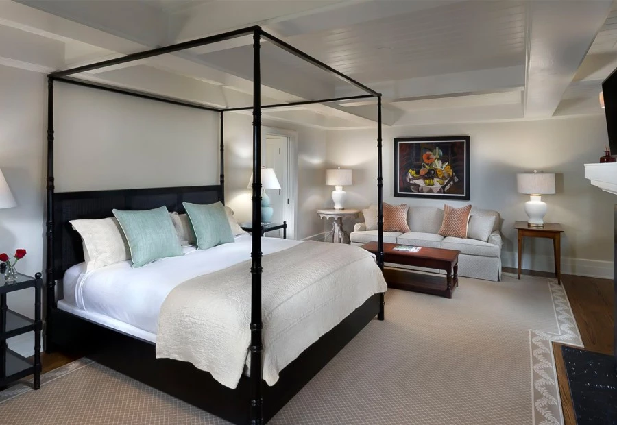 a bedroom with a four poster bed and a couch