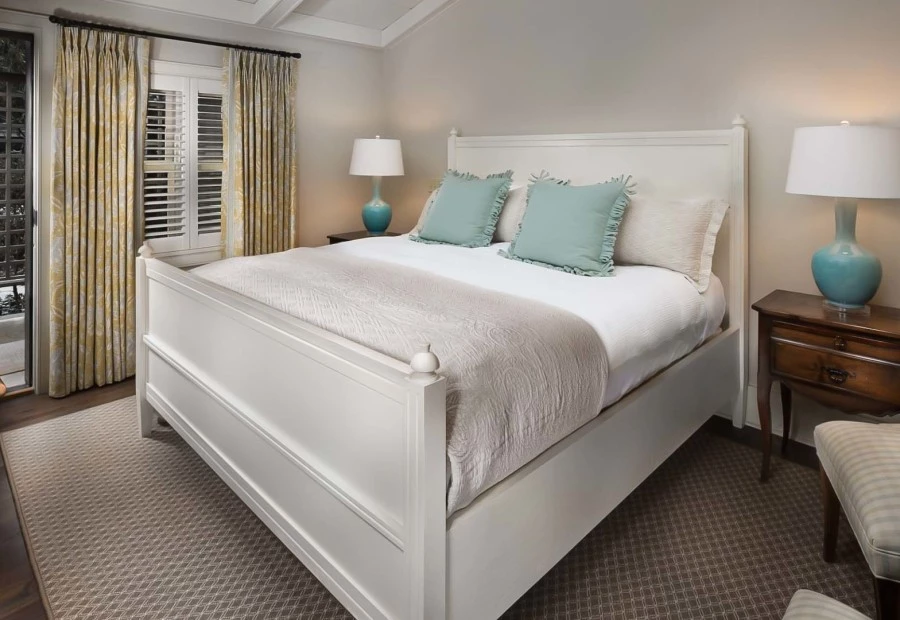 a bed with pillows and a lamp in a room