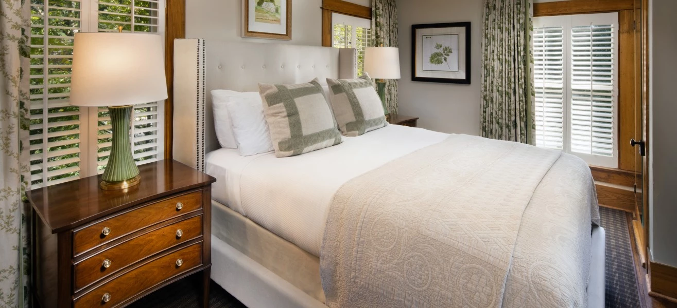 a bed with a white bedding and a lamp