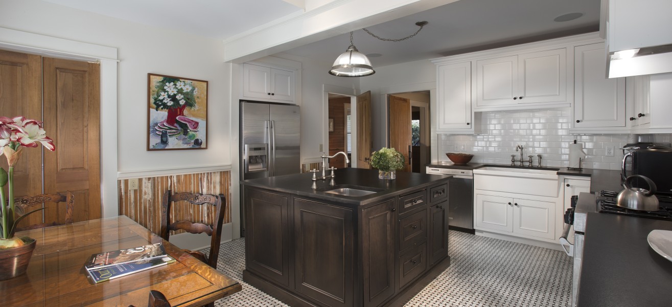 a kitchen with a black island and a table