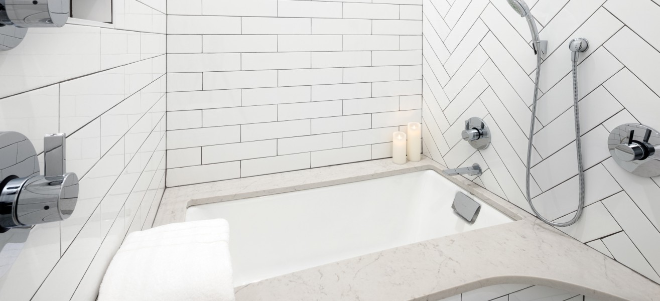a bathtub with candles and a shower head