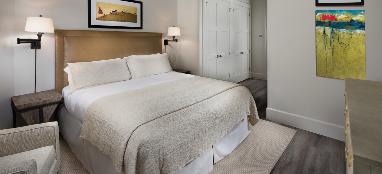 a bedroom with a bed and a painting on the wall