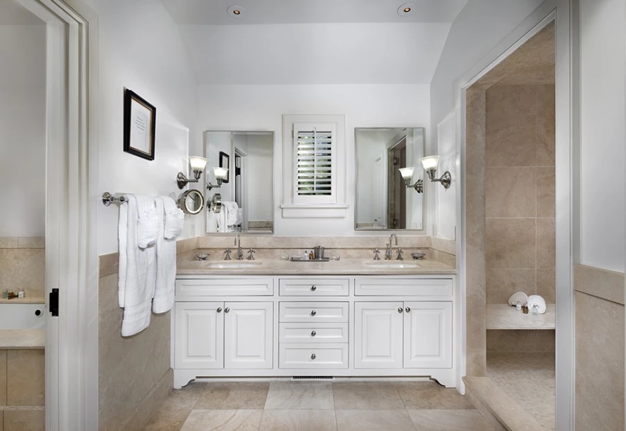 a bathroom with white cabinets and white towels