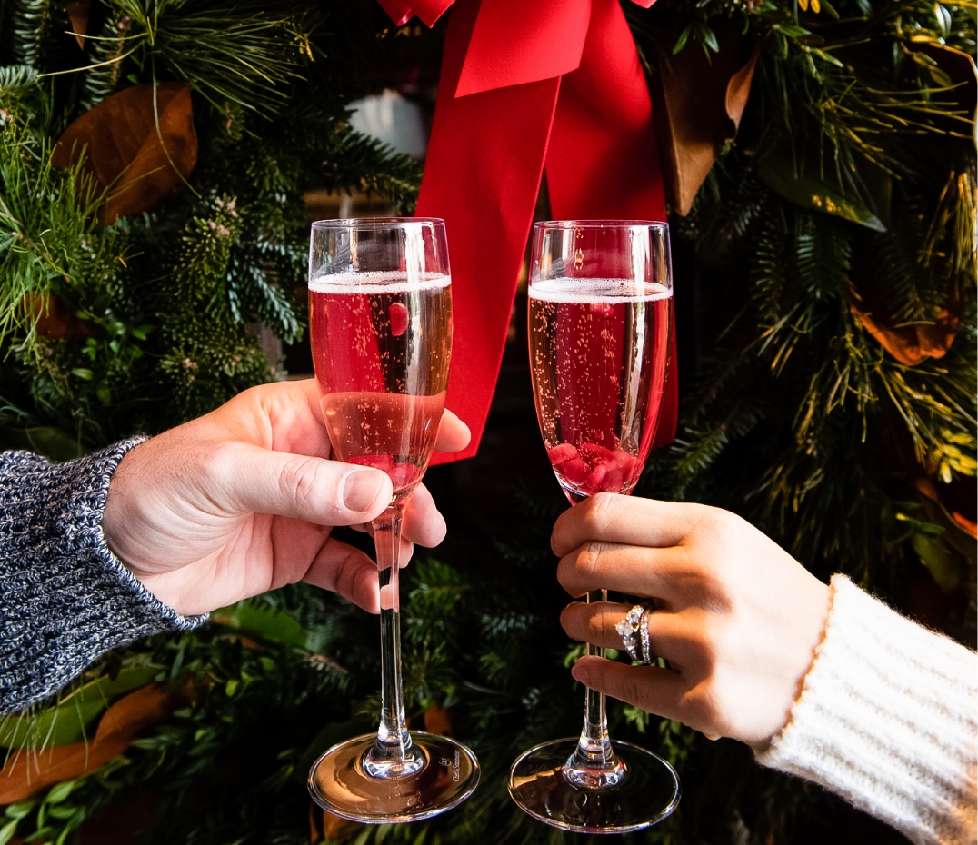 a pair of hands holding champagne glasses