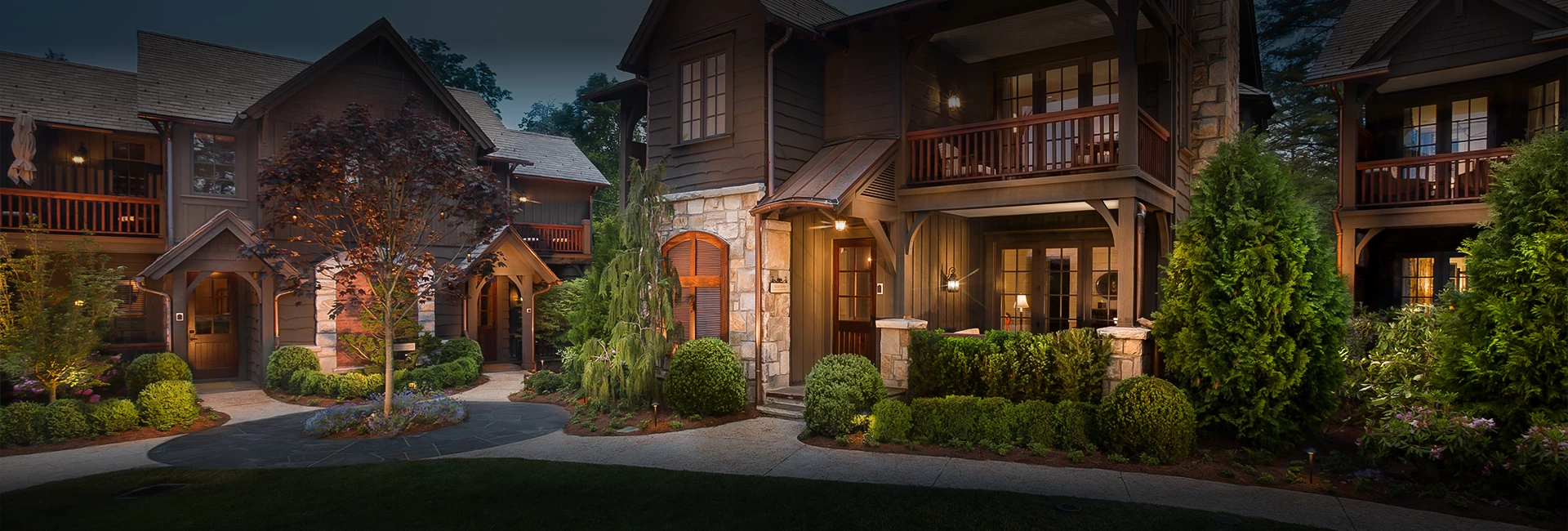 a house with a stone wall and a stone wall and a stone walkway