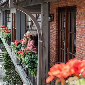 a woman standing on a balcony with flowers