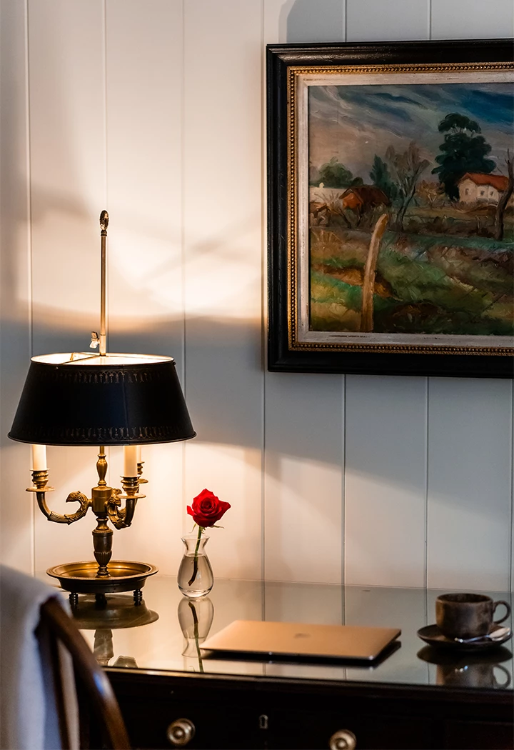 a lamp on a table next to a painting