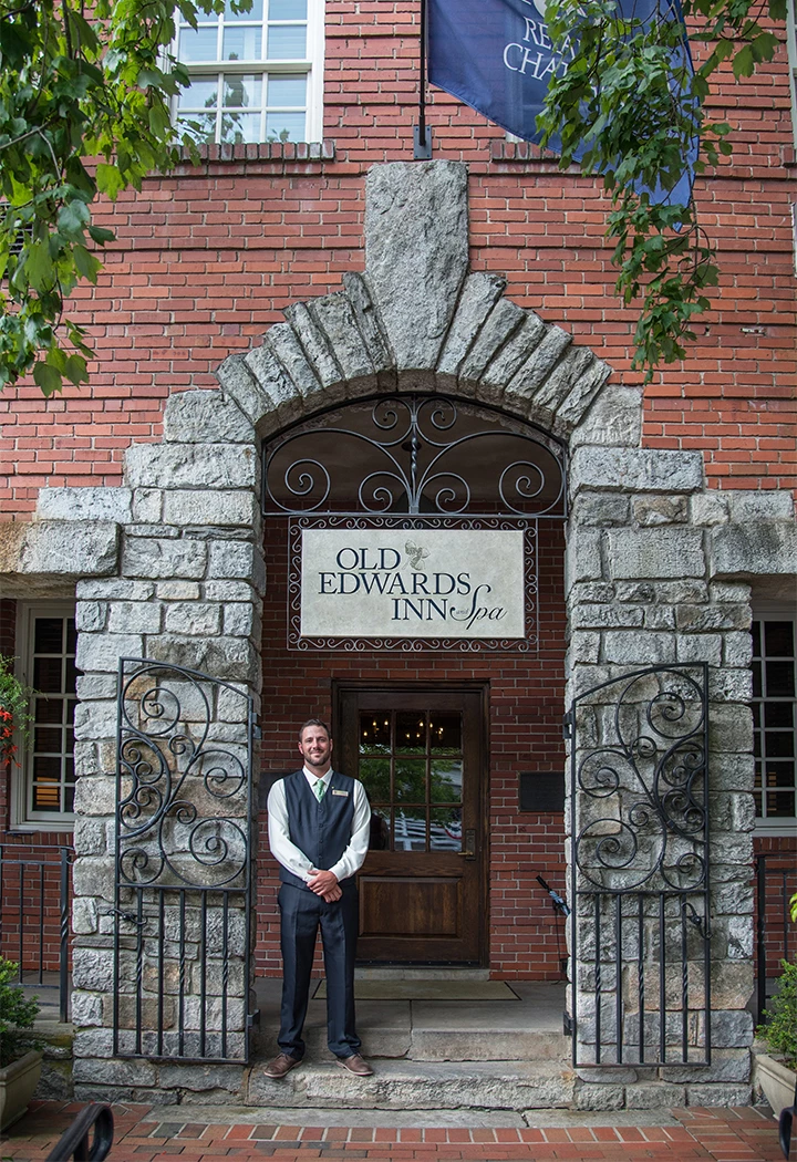 a man standing in front of a brick building
